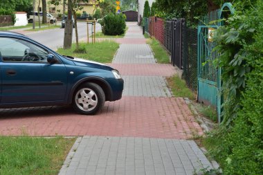 Kaldırımda duran bir yolcu arabası yaya geçidini kapatıyor. Gün.