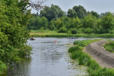 Güneşli bir yaz gününde nehirde kayıklar ve kanolar akıyor. İyi günler. Yaz. 