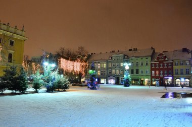 Soğuk bir kış gecesinde sokak lambalarıyla aydınlatılan kış süslemeleri ve sokaklarda kar. Gece. 