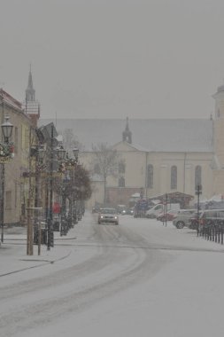 Karla kaplı yollar, karda tekerlek izleri ve yoğun kar yağışı sırasında karla kaplı arabalar. Gün. 