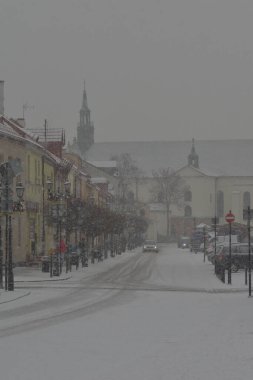 Karla kaplı yollar, karda tekerlek izleri ve yoğun kar yağışı sırasında karla kaplı arabalar. Gün. 