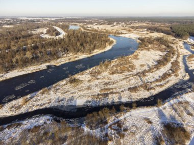Güneşli bir kış gününde, nehir kenarları ve karla kaplı öküz kuşları bir İHA 'dan fotoğraflandı. Gün.