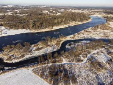 Güneşli bir kış gününde, nehir kenarları ve karla kaplı öküz kuşları bir İHA 'dan fotoğraflandı. Gün.
