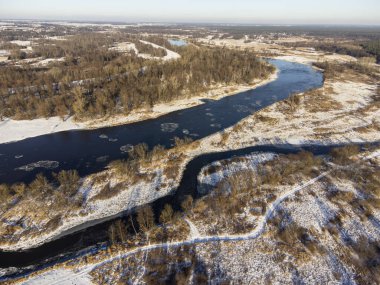 Güneşli bir kış gününde, nehir kenarları ve karla kaplı öküz kuşları bir İHA 'dan fotoğraflandı. Gün.