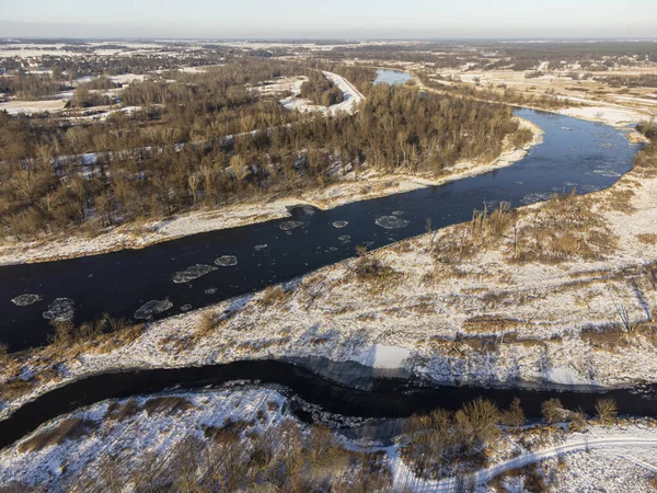 Güneşli bir kış gününde, nehir kenarları ve karla kaplı öküz kuşları bir İHA 'dan fotoğraflandı. Gün.