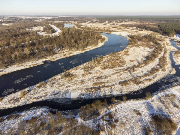 Güneşli bir kış gününde, nehir kenarları ve karla kaplı öküz kuşları bir İHA 'dan fotoğraflandı. Gün.