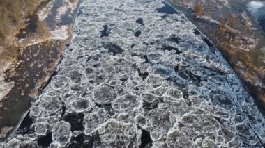 Kış güneşli bir günde, su donduktan bir dakika sonra nehrin üzerinden uçuyorum..