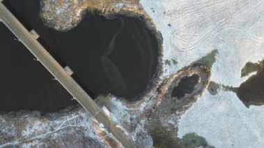 Güneşli bir kış gününde şehrin, nehrin ve köprülerin üzerinde insansız hava aracı uçuşu.