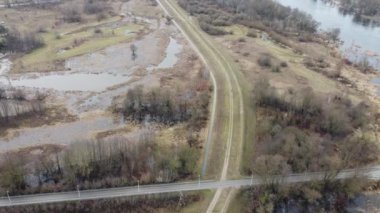 Serin bir sonbahar gününde nehrin kuş bakışı manzarası, sel setleri ve bir köprü. Kış.