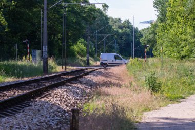 Güneşli bir yaz gününde tren ve araba kesişiyor.. 