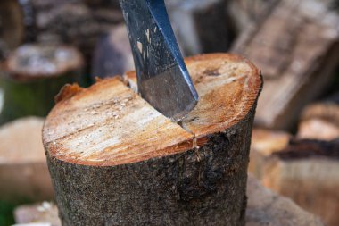 Açık bir günde odun keserken bir balta ve kütük..