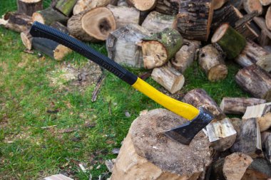 Açık bir günde odun keserken bir balta ve kütük..