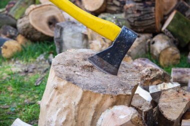 Açık bir günde odun keserken bir balta ve kütük..