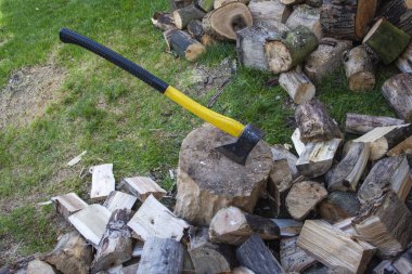 Açık bir günde odun keserken bir balta ve kütük..