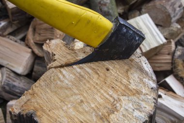 Açık bir günde odun keserken bir balta ve kütük..
