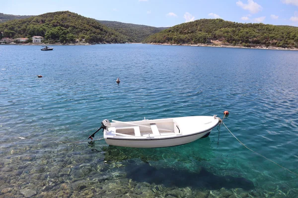 海の海岸 ポヴリヤ クロアチアの絵のように美しい湾の海景 白いボート 海の穏やかな澄んだ水 松で覆われた山々 アドリア海沿岸のターコイズブルーの海を背景にしたモーターボート ブラック島 クロアチア ストックフォト