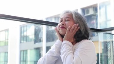 Yaşlı kadının portresi evinin penceresinde oturuyordu. Evinde rahatlatıcı, basit jestler yapıyor..