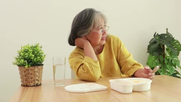 Starsza Azjatka Siedzi Przy Stole Domu Jedząc Niesmaczne Niedożywione Plastikowe — Wideo stockowe