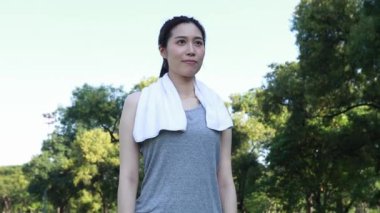 Asyalı kadının portresi sabahları güzel manzara parkında egzersiz yapmadan önce hareketsiz durup meditasyon yapıyor..
