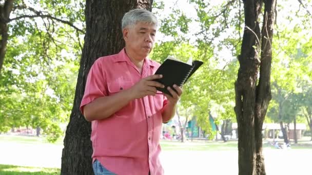 Anciano Asiático Hombre Pasa Tiempo Libre Leyendo Diario Bajo Sombra — Vídeo de stock