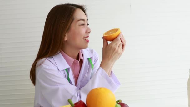 女性栄養士は 衛生的な食事を監督し 良好な健康を維持するためにビタミンCとオレンジを食べることを奨励 — ストック動画