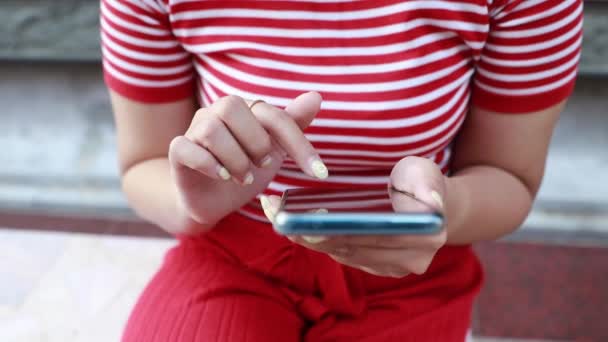 坐在智能手机上享受手指滑动的女人在屏幕上寻找应用程序 — 图库视频影像