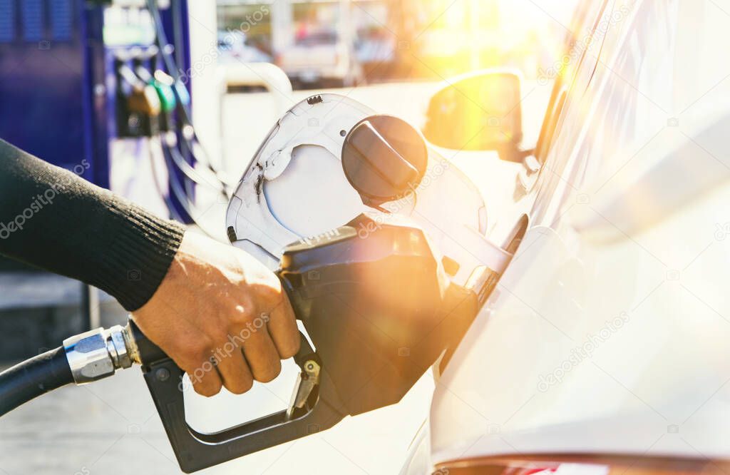 Gasoline business concept : Man's hands provide fuel for cars in high-quality and modern service stations : Blurred background