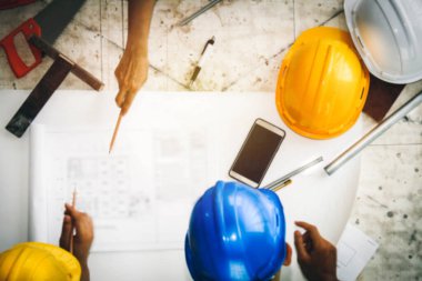 Bulanık resimler. Endüstriyel mimarlardan oluşan bir grup inşaat projelerini tartışmak için bir masada birlikte çalışıyorlar..