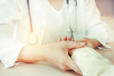 Asyalı kadın doktorlar kadın hastaların bileklerindeki nabız oranını ve hastanedeki semptomlarını kontrol ediyorlar..