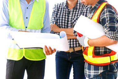 Endüstriyel mühendislik ekibi: Mühendisler, mimarlar, üç erkek ve kadın çalışma sırasında görüşlerini belirttiler ve ifade ettiler. Projenin beyaz arkaplan planını dikkatlice izleyerek.