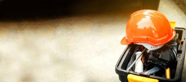 Güvenli çalışma konsepti: Turuncu kask bir tamircinin alet kutusunun üzerinde bulunur: Sancak kopyalama alanı