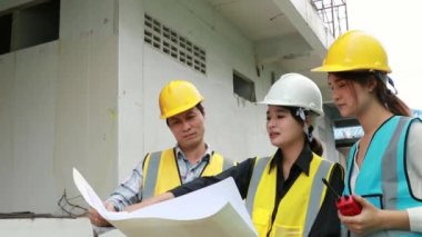İnşaat işçileri, mühendisler, mimarlar, Asyalı kadın ve erkekler birlikte çalışarak geliştirme projesi ekibini oluşturuyorlar..