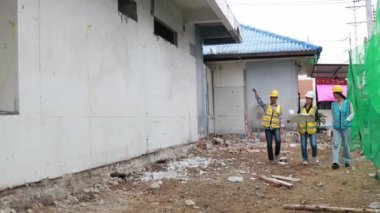 İnşaat işçileri, mühendisler, mimarlar, Asyalı kadın ve erkekler birlikte çalışarak geliştirme projesi ekibini oluşturuyorlar..