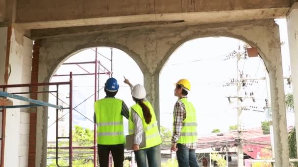 Инженеры Женщины Чертежами Шлемах Желтых Жилетах Тщательно Изучают Архитектурное Строительство — стоковое видео