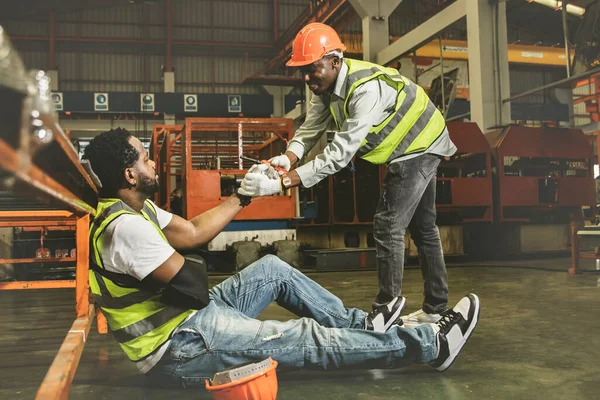 Friendship and sympathy for workers injured during work concept : Male african american worker injured in arm wearing cast sits in pain gets sympathy for help to take sick leave to heal.