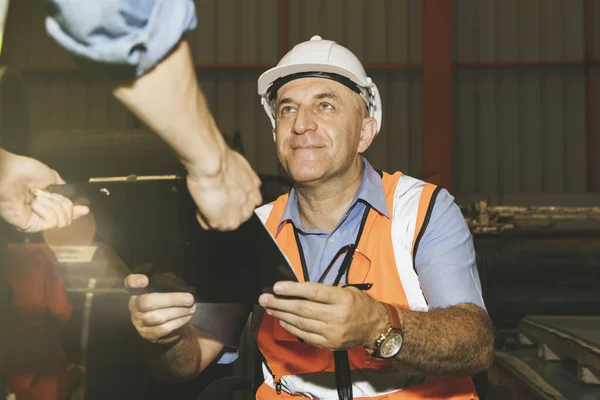 Senior engineering chief accepting assignments from male subordinate workers with excellent teamwork in industrial factory sites : Foreman who is responsible for professional production inspection.