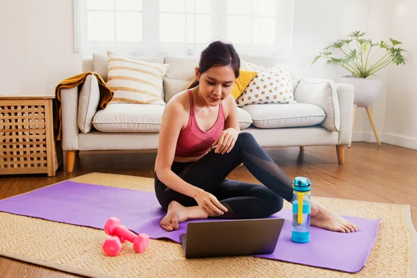 Young asian woman lifestyle exercises living room study at home with exciting interest in researching the right way to lose weight : Happy women prepare dumbbells and yoga mats for healthy sports.