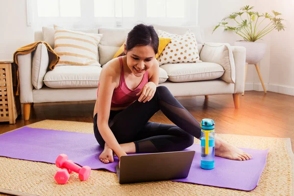 Cute Asian woman exercises  living room study at home with exciting interest in researching the right way to lose weight : Happy women prepare dumbbells and yoga mats for healthy sports.