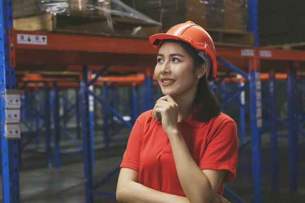 Warehouse worker charming and agile portrait beautiful asian woman wearing safety helmet checking stock in the warehouse confident and ready to work : International export warehousing business concept
