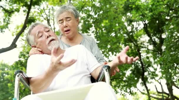 冠動脈疾患に苦しむ高齢男性は麻痺し 愛する妻の世話の下で自分自身の世話をすることはできません 古い年齢の医療と健康保険の概念 — ストック動画
