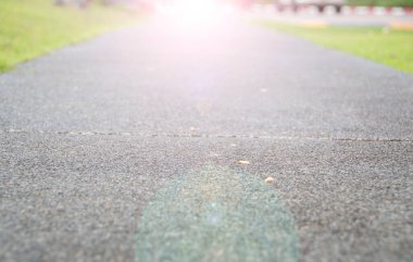 Yürüyüş yolu ve yeşil çimenler gün ışığında bulanıklaşır.