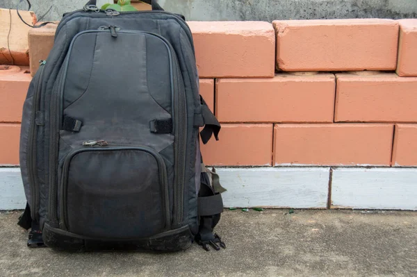 Black Camera Backpack Leaning Brick Wall Obraz Stockowy