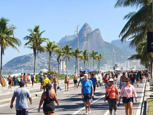 RIO DE JANEIRO - MAY 1: Locals and tourists enjoy a walk on the water front road Av. Vieira Souto that is closed for traffic on sundays in Ipanema, Rio de Janeiro, Brazil on May 1st, 2022. 