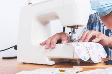 İnsanlar iplik dikiyor. Küçük bir dikiş makinesinin iğnesine, insanlara ve iş hobisine girmeye hazırlan..