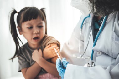 Bulanık görüntüler, 3 yaşındaki Asyalı bir kız, beyaz geçmişi olan, çocuk sağlığı ve aşı kavramına karşı aşı yapmaya hazırlanan doktordan korkuyor..