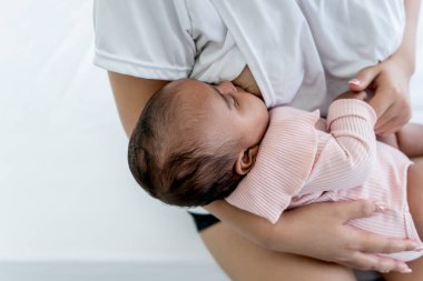 Yeni doğan bebek 3 aylık, annesinin memesinden süt içiyor, beyaz arka planda, çocuk sağlığı için yararlı süt kavramı anne sütü..