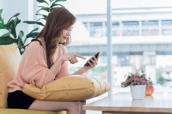 Mujer Asiática Atractiva Joven Sentado Sofá Utilizando Aplicación Los Teléfonos —  Fotos de Stock