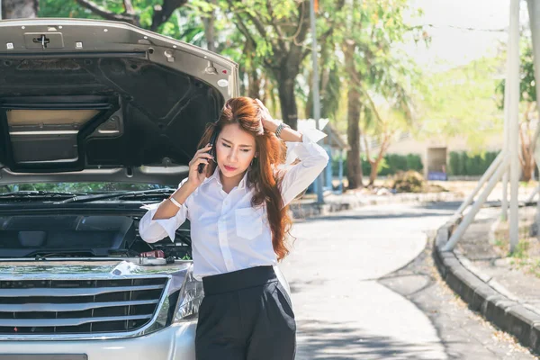 彼女のピックアップトラックが壊れていたので 助けを求めるために携帯電話を使用してアジアのビジネス女性は 旅行中に 人々や交通の概念に — ストック写真