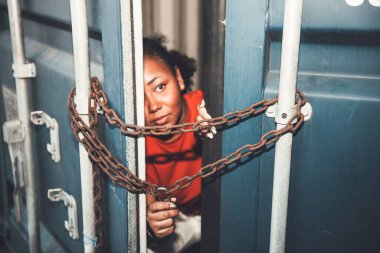 Demir zincirler ve anahtarlarla kaplı bir konteynırın kapısının içinde birçok kadın insan ticareti ve yasadışı göçmenlik kavramına giriyordu..