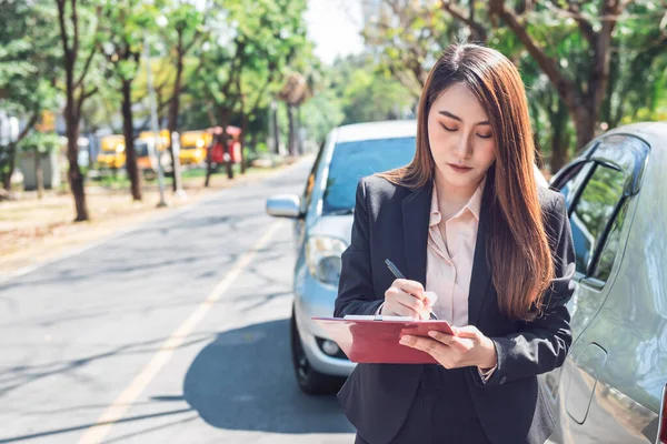 アジアの女性は 保険代理店が事故車事故報告書を書いていることを通知し 人々と交通保険の概念に — ストック写真